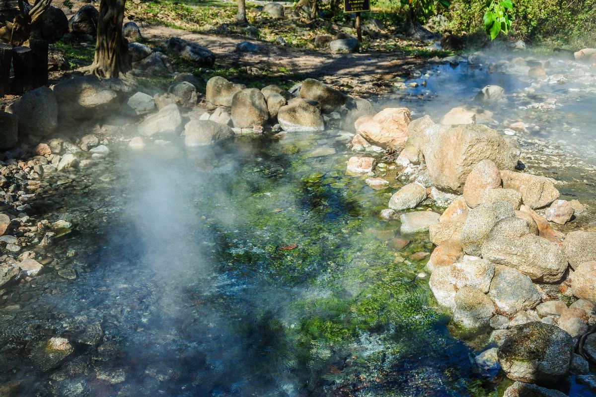 Natural hot spring surrounded by lush forest in Mae Hong Son, Thailand